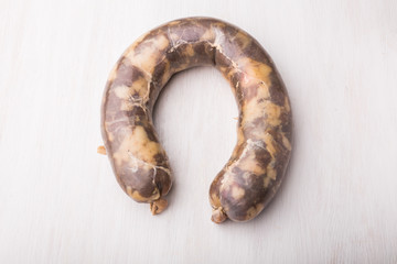 Obraz premium Food, meat and delicious concept - sausage made with horse meat on the table