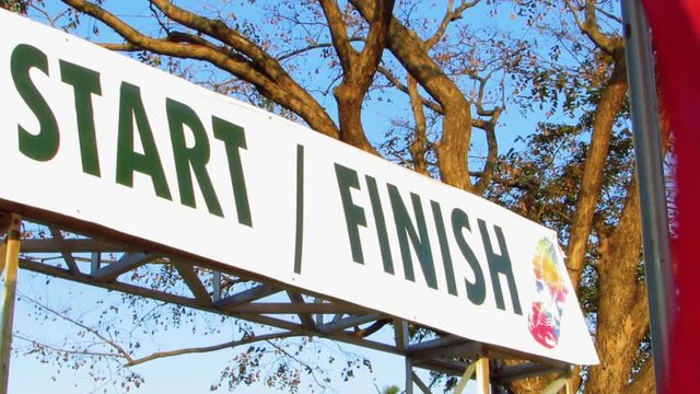 Start - Finish Signage in a Charity Racing Events with Flag Waving in the Background
