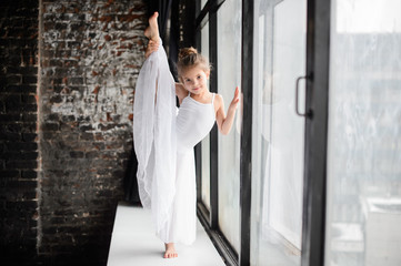 Little girl gymnast, performs various gymnastic and fitness exercises.