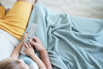 Top view over the family watching televison on the couch