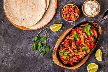 FAJITAS with colored pepper and onions, served with tortillas.
