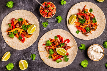 Fototapeta na wymiar FAJITAS with colored pepper and onions, served with tortillas.