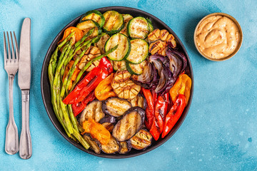 Grilled vegetables on a plate with sauce.