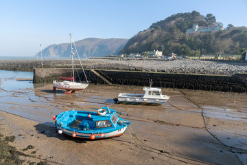 Lynmouth, North Devon, England, UK. March 2019. Lynmouth pier and  small boats on the West Lyn...