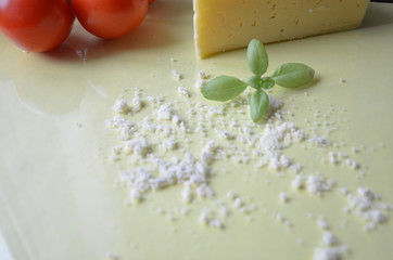 Italian food background with tomatoes, basil, parmesan. Ingredients onellow table Copy space Top view