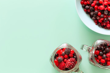 A healthy cocktail of forest fruits on a background of pastel green glass top, Empty space for an inscription