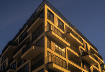 A modern apartment building below a blue sky