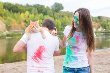 Obraz premium Pet, summer tourism, festival holi and nature concept - funny man and woman with cat on natural background