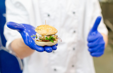 Chef holding mini burger made from salmon 