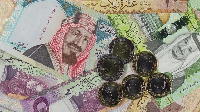 Saudi Arabia riyal banknotes and coins rotating. Saudi Arabian money, currency. 4K stock video footage