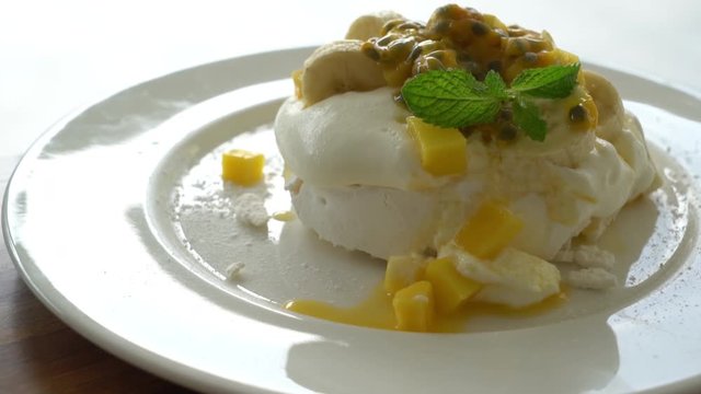 fruit dessert with whipped cream, mint and granola, close-up view in plate with horizontal view