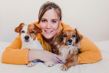 young woman and her cute dog sitting on bed. love for animals concept. top view