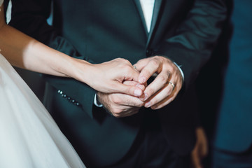 Obraz na płótnie Canvas Bride and groom holding hands in church
