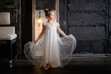 Beautiful girl in white dress posing indoor