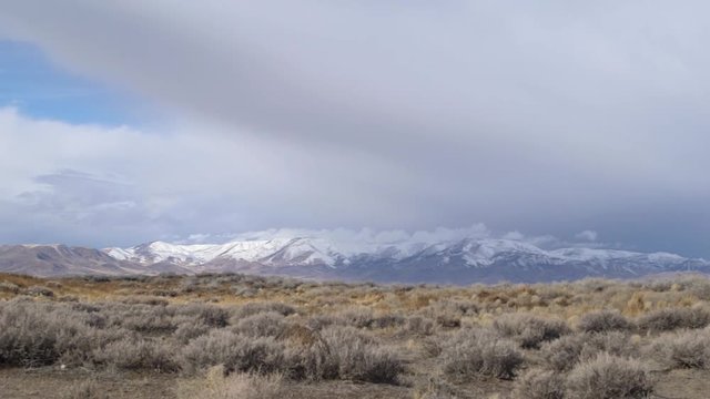 Windy cloudy desert with mountains the the background