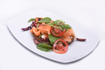Top view Ham sandwich with tomatoes and herbs. Dark bread on a white background.