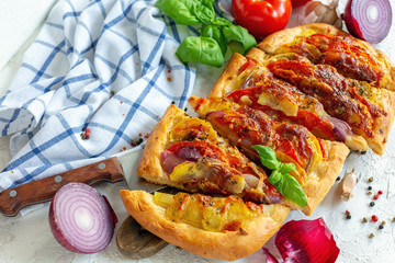 Vegetable pie with potatoes, onions and tomato.
