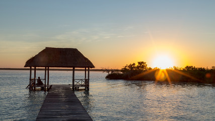 Obraz premium Sunrise, meditation in the lagoon of the seven colors, in Bacalar, Quintana Roo, Mexico.