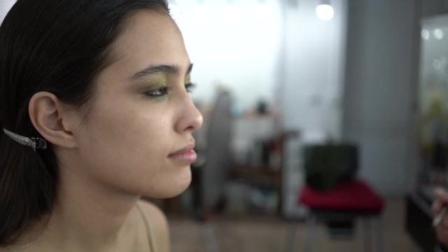 makeup artist makes makeup model