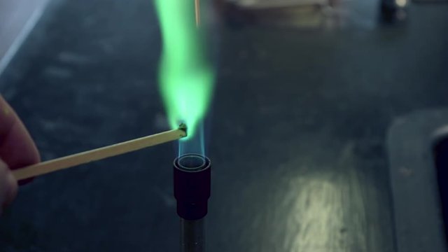 Close up of blue bunsen burner flame followed by copper flame test burning green