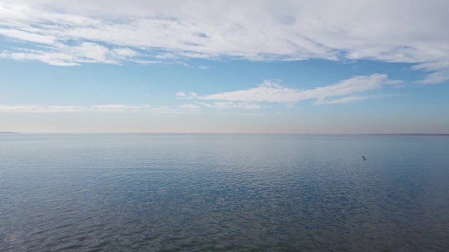 Wide sea view on a sunny day, Seagulls flying along on the Ocean.