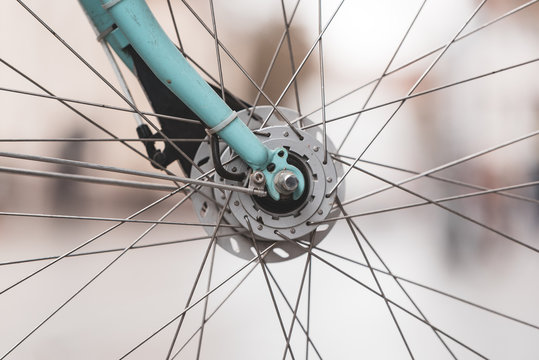 Close Up Of The Front Wheel With Spikes And Part Of The Bike Fork Of Turquoise Bike