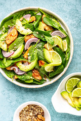 Healthy avocado salad with chicken breast and spinach, flat lay, top view