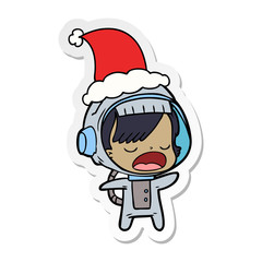 sticker cartoon of a talking astronaut woman wearing santa hat