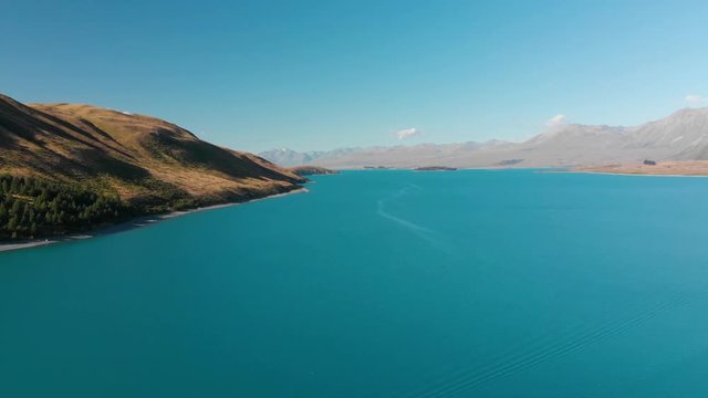 Aerial shot of Lake Tekapo, New Zealand and its Beautiful Turquoise Blue Water wiht mountains in background