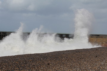 large waves are splashing at the pier in dieppe, normandy at a stormy day in autumn