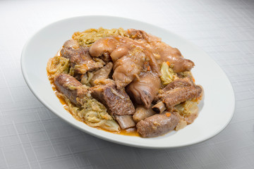 White plate with pork meat and savoy cabbage