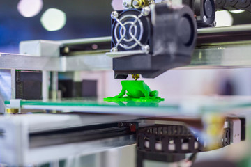 3D printer prints physical 3D model with plastic wire filament at modern technology exhibition....