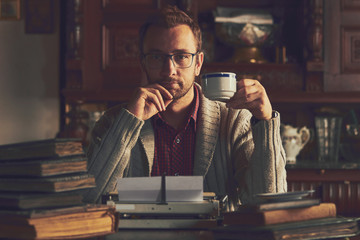 Young man writing on old typewriter.