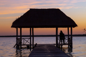 Bacalar, Mexico -January 20,2019; Friends watching the sunset at the pier of the Bacalar Lagoon(lagoon of the seven colors) Quintana Roo Mexico