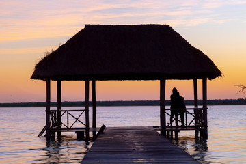 Bacalar, Mexico -January 20,2019; Friends watching the sunset at the pier of the Bacalar Lagoon(lagoon of the seven colors) Quintana Roo Mexico