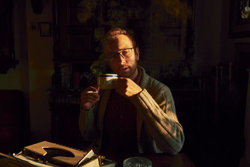 Young man writing on old typewriter.