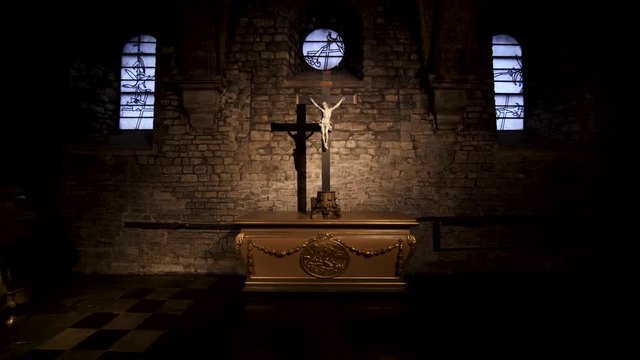 Christ on a cross with a strong shadow, A little altar in Basilica of our Lady Church, Maastricht, Netherlands, 4k footage of a crucifix