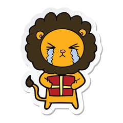 sticker of a cartoon crying lion with gift