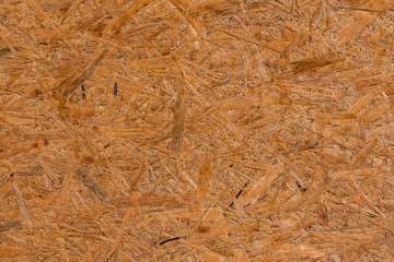 A horizontal texture of yellow chipboard for construction with knots