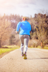 Sporty young woman is jogging in nature