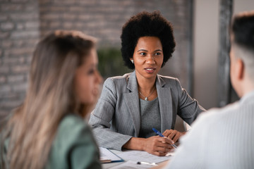 African American financial advisor having a meeting with clients in the office.