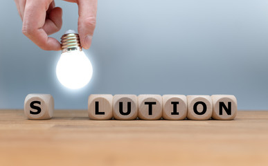 A Symbol for finding a solution. Dice and a light bulb form the word 