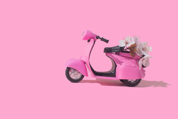 Fototapeta na wymiar Pink retro toy car delivering bouquet of flowers box on pink background. February 14 card, Valentine's day. Flower delivery. 8 March, International Happy Women's Day. Mother's day