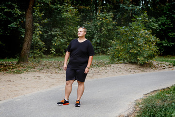 fat guy on a walkway in a summer park