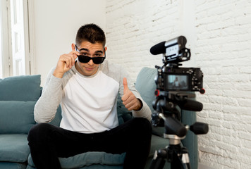 Young man blogger recording a video in streaming on camera for the followers on the internet