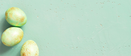 Banner with green Easter eggs with golden spots