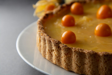 Lemon curd pie. Homemade delicious pie ,tart filled with lemon curd. Sweet dessert. Lemon curd pie decorated with physalis.
