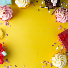 Bright, colorful birthday background with cupcakes, gift boxes, sweets and decorations. Copy space. Yellow background. square image.