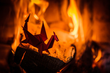 Origami paper toy dragon on the background of burning fire