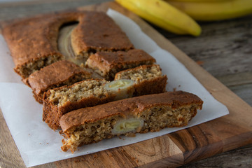 Fototapeta na wymiar Banana bread with oat flour. Top view of homemade banana bread on wooden background. Ideas and recipes for healthy diet breakfast.